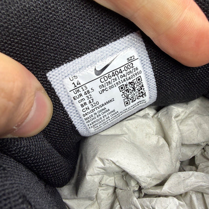 Nike black trainers with mesh upper, reflective detailing, and padded collar.