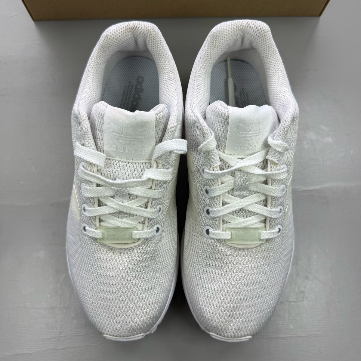 Adidas ZX Flux white running trainers with clear grey accents and minimalist design.