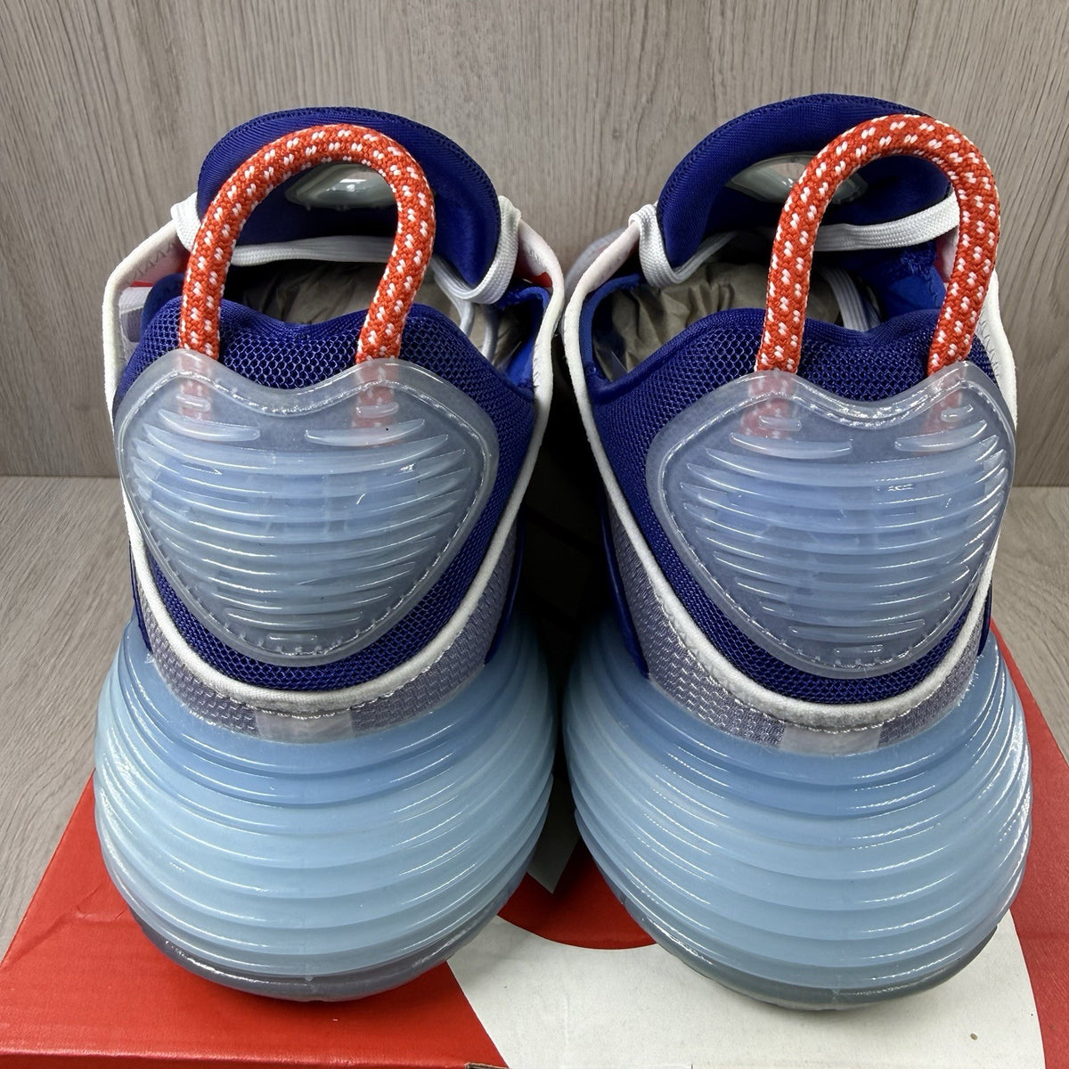 Nike Air Max 2090 trainers white with red and blue accents, featuring logo details.