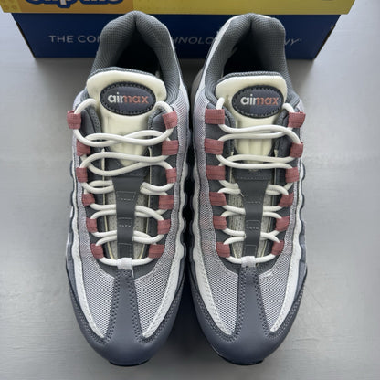 Nike Air Max 95 grey trainers with red accents and white sole, featuring iconic logo.