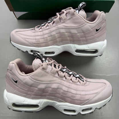 Nike trainers pink with white accents and Air Max cushioning details.