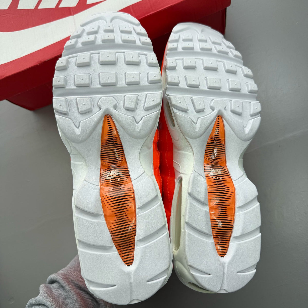 Nike Air Max 95 orange trainers with white overbranding and logo details.