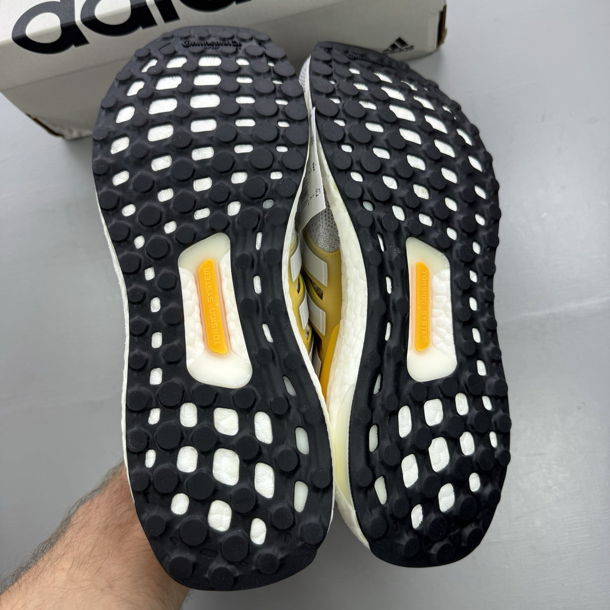 Adidas Ultra Boost 1.0 grey trainers with bold gold accents and white sole.