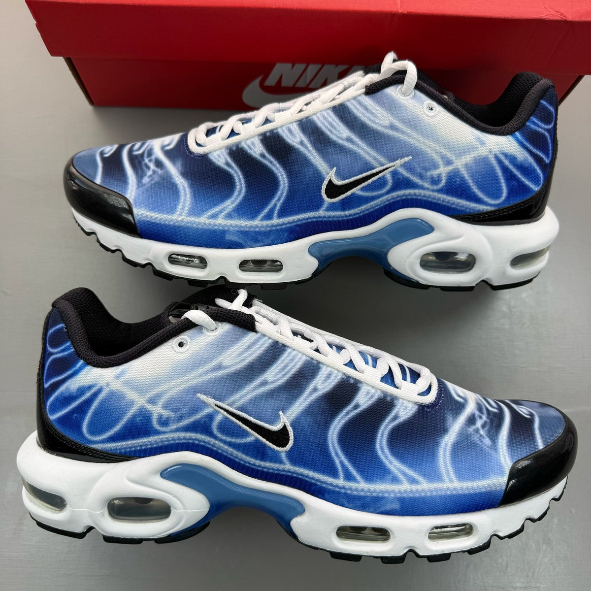 Nike Air Max Plus TN blue trainers with distinctive wave pattern and logo.