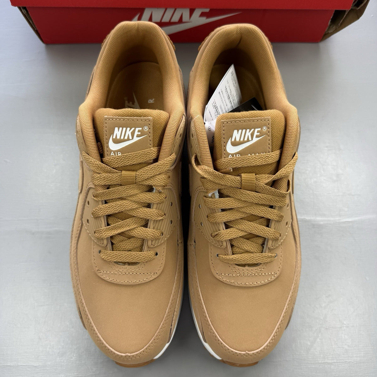 Nike Air Max 90 Premium beige trainers with white accents and textured suede material.