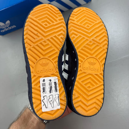 Adidas blue kids trainers with white and orange accents, featuring logo detail.