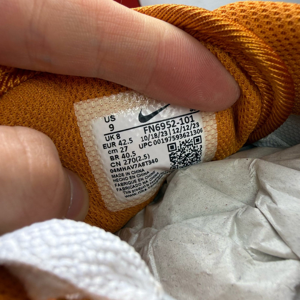 Nike Air Max 1 white trainers with Monarch orange and black accents, featuring logo details.