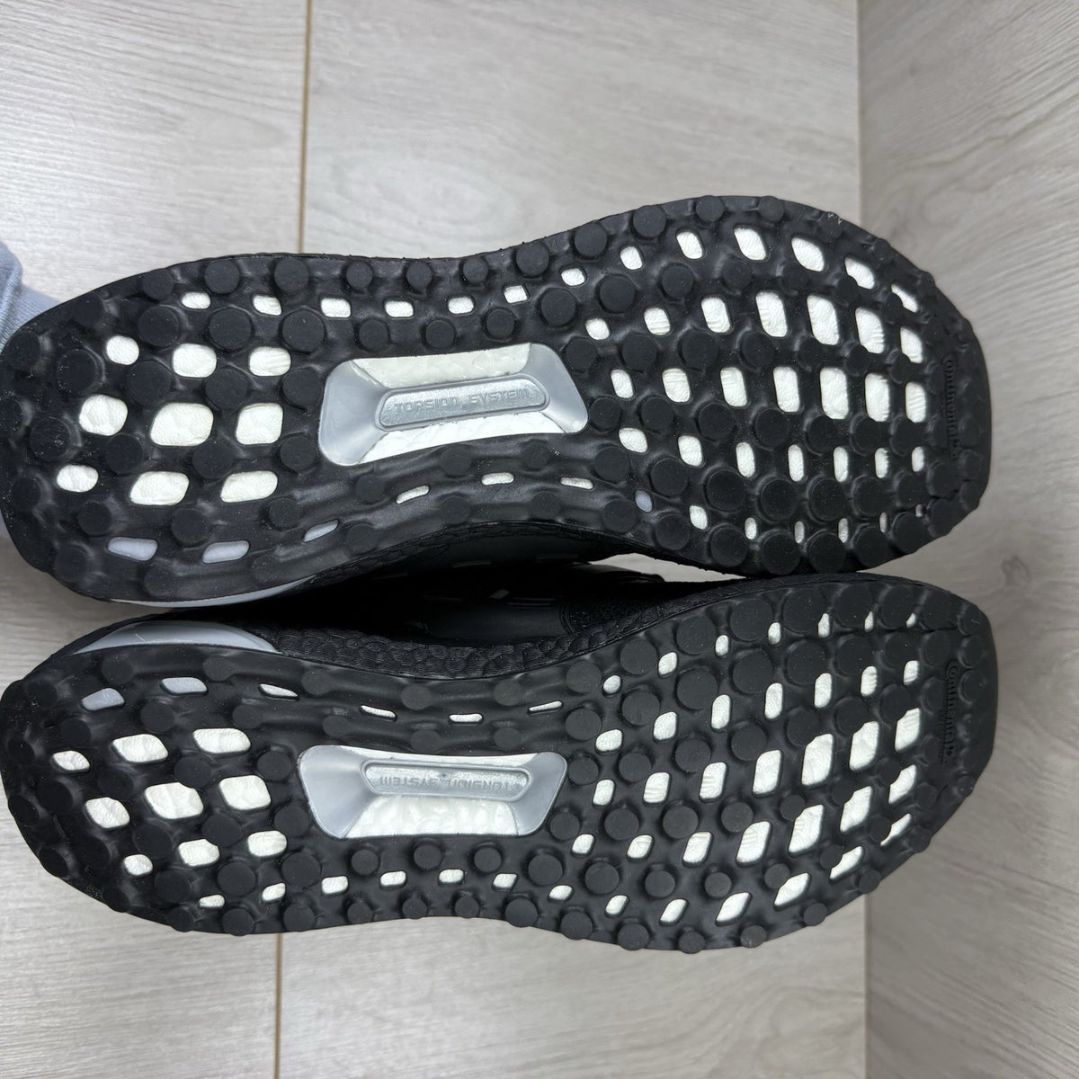 Adidas black trainers with white polka dot pattern and iconic three-stripe logo.