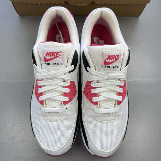 Nike Air Max 90 trainers white with pink and black accents, featuring logo details.