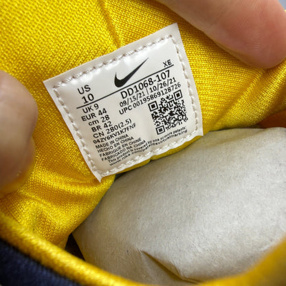 Nike Air Huarache white sneakers with yellow maize and navy accents, featuring logo details.