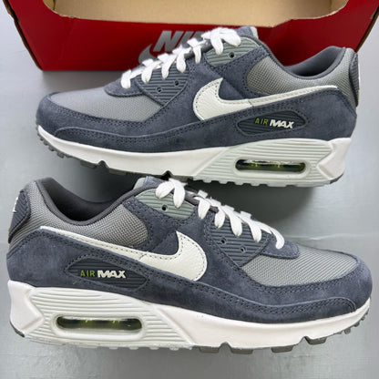Nike Air Max 90 PRM grey trainers with white accents and distinctive logo details.