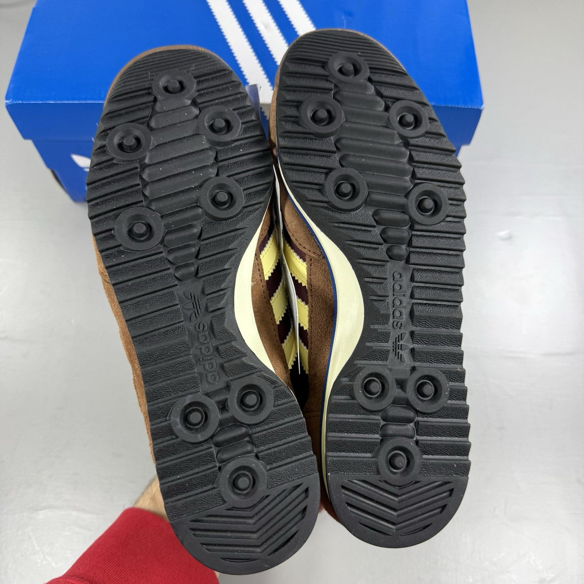 Adidas brown trainers with retro design and classic logo detail.