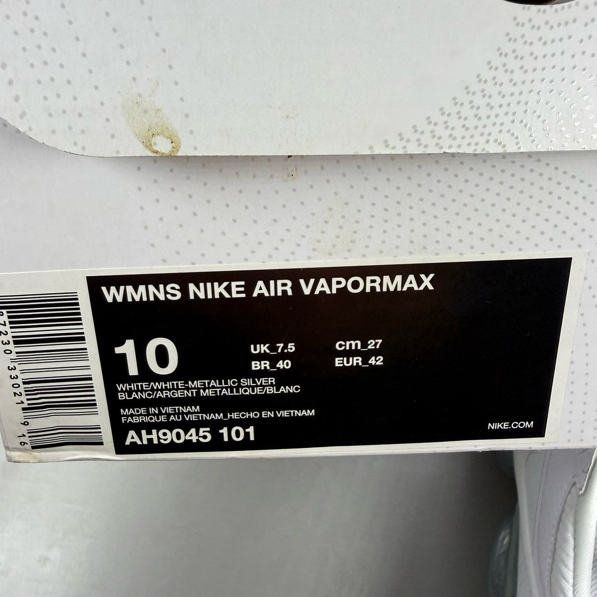 Nike white trainers with gum sole and silver accents, featuring breathable mesh upper.