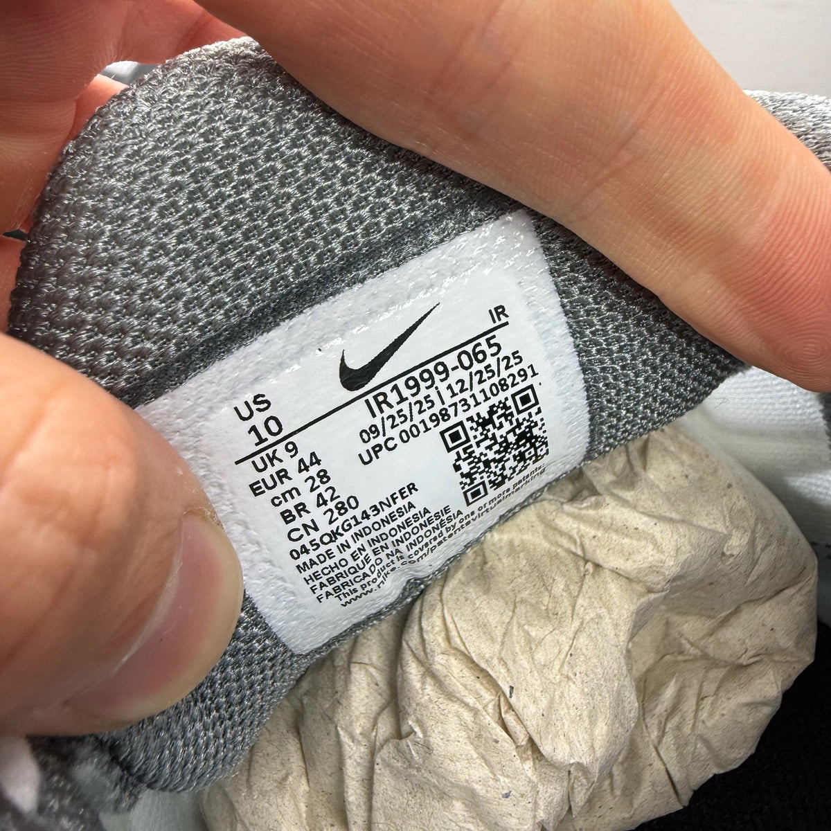 Nike Air Max Plus TN grey trainers with white and liquid lime accents, featuring logo details.
