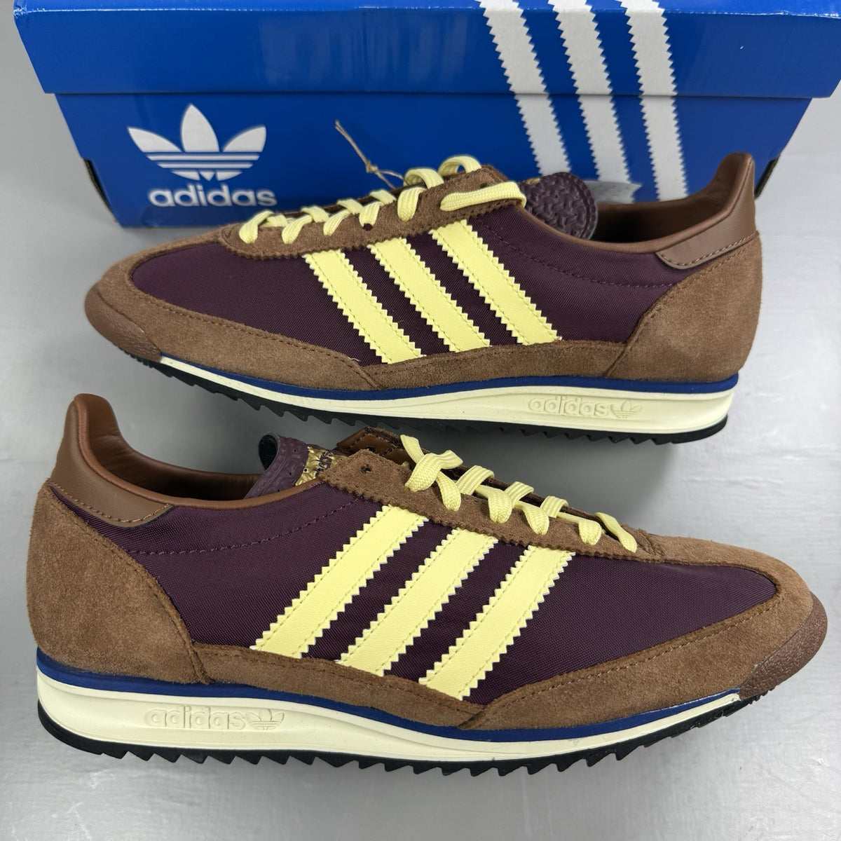 Adidas brown trainers with retro design and classic logo detail.
