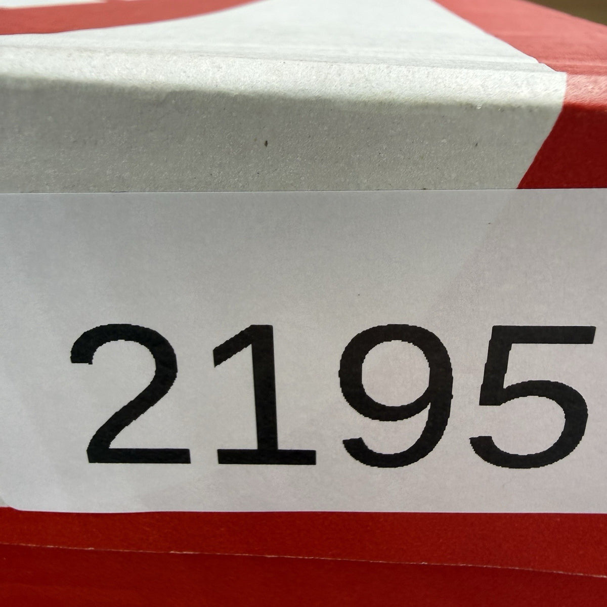 Nike Air Max Plus TN white trainers with university red and grey accents, featuring signature logo.