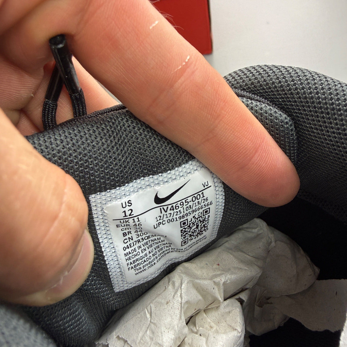 Nike black trainers with grey accents and Air Max cushioning detail.