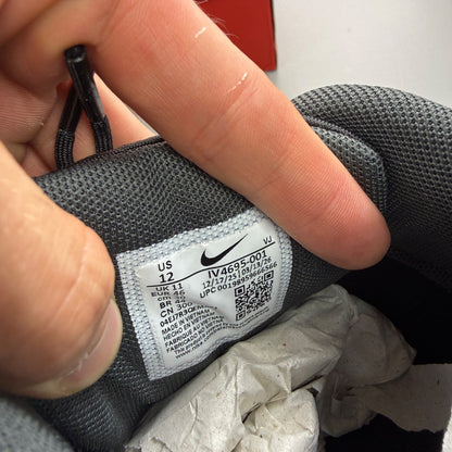 Nike black trainers with grey accents and Air Max cushioning detail.