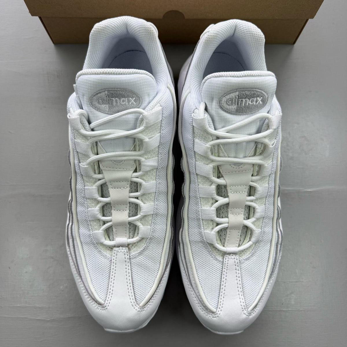 Nike Air Max 95 white trainers with mesh and leather upper, reflective accents.