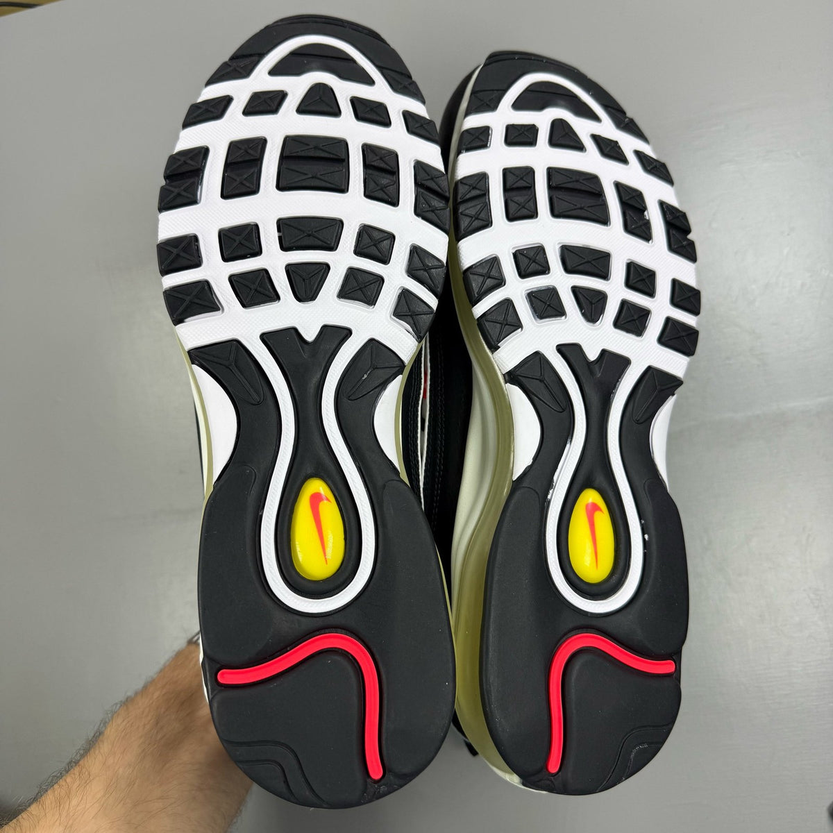 Nike Air Max 98 white trainers with black and yellow accents, featuring a sleek design.