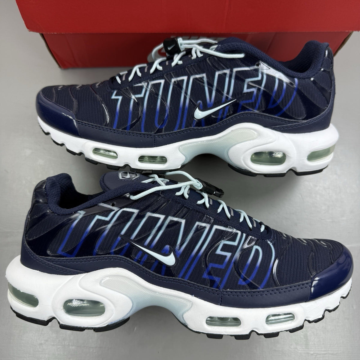 Nike Air Max Plus trainers navy blue with signature swoosh logo and mesh detailing.