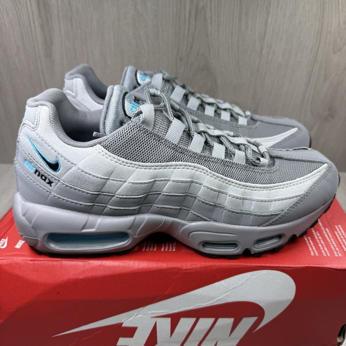 Nike Air Max 95 trainers grey with aqua blue accents and retro logo details.