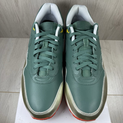 Nike Air Max 1 trainers green with white and silver accents, featuring iconic logo.