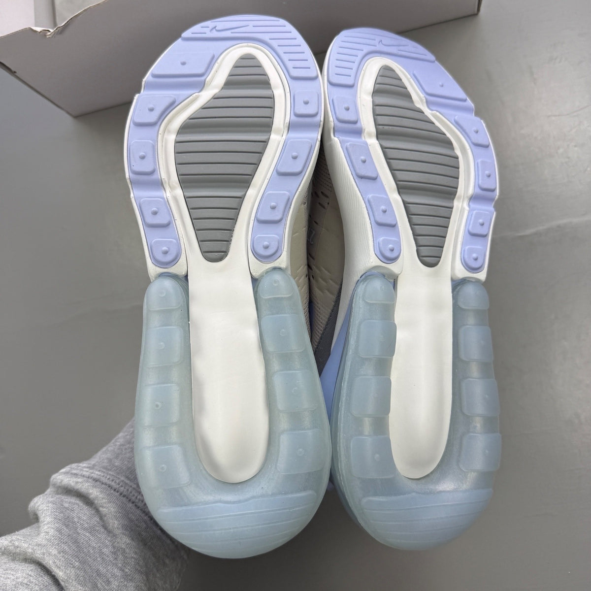 Nike grey trainers with Air Max cushioning and logo detail on the tongue.