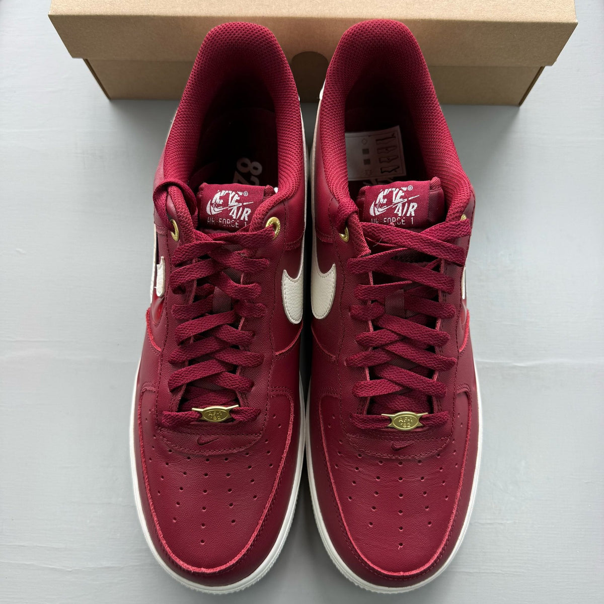 Nike Air Force 1 red trainers with premium materials and classic silhouette.