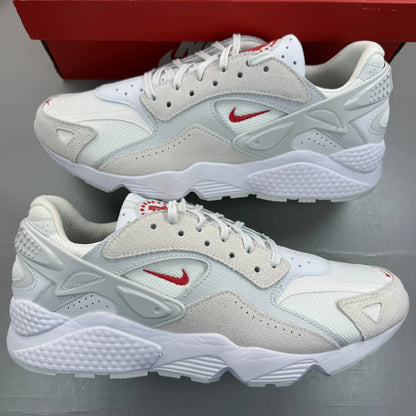 Nike Air Huarache Runner white trainers with red accents and signature logo.