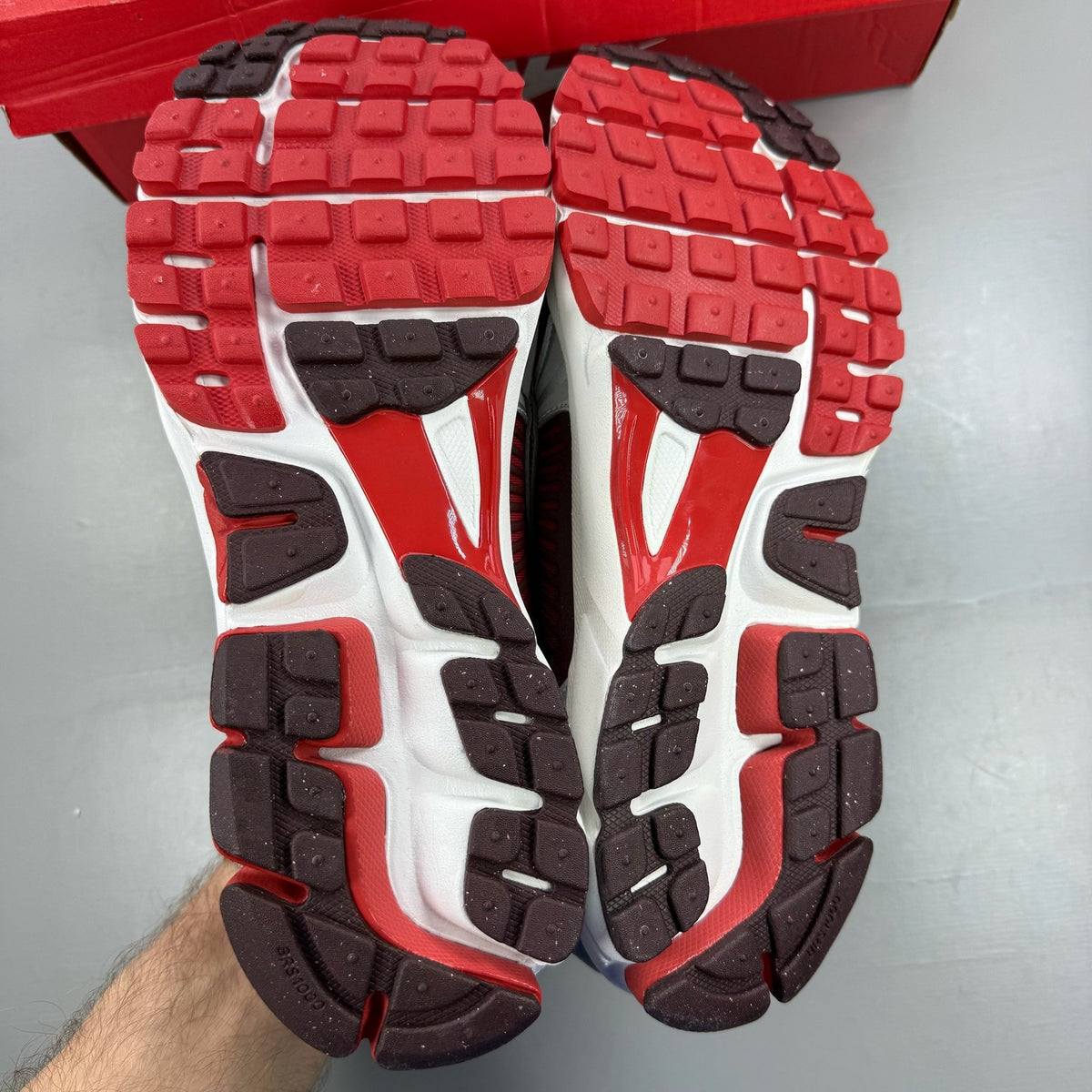 Nike Zoom Vomero 5 black trainers with red accents and white logo details.