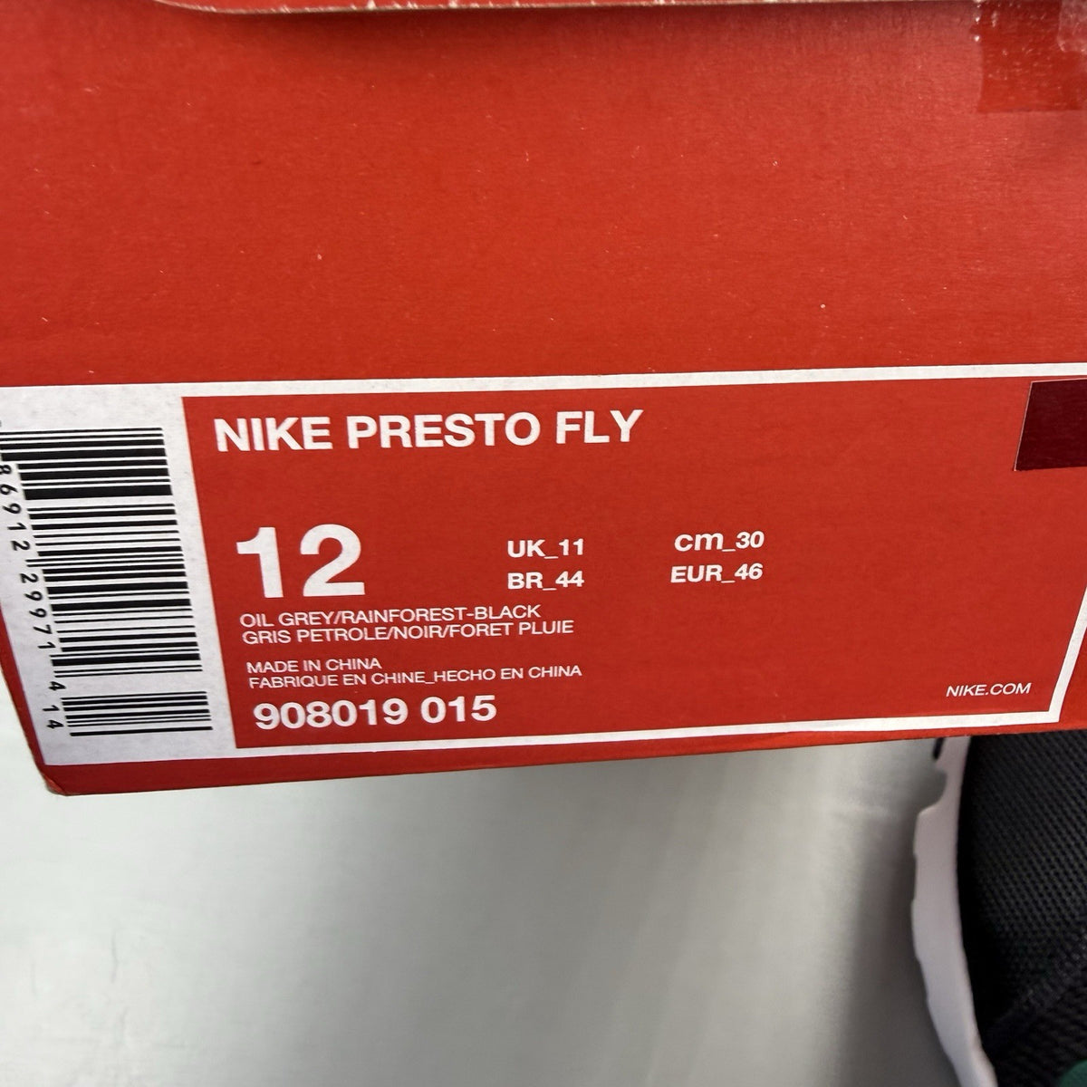 Nike Presto Fly black trainers with grey accents and white sole, featuring logo details.