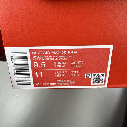 Nike Air Max 90 Premium grey trainers with black accents and signature swoosh logo.