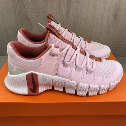 Nike Free Metcon 5 pink foam trainers with white accents and logo detailing.