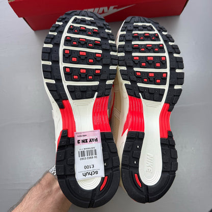Nike P-6000 trainers white with red accents and mesh detailing, brand logo on tongue.