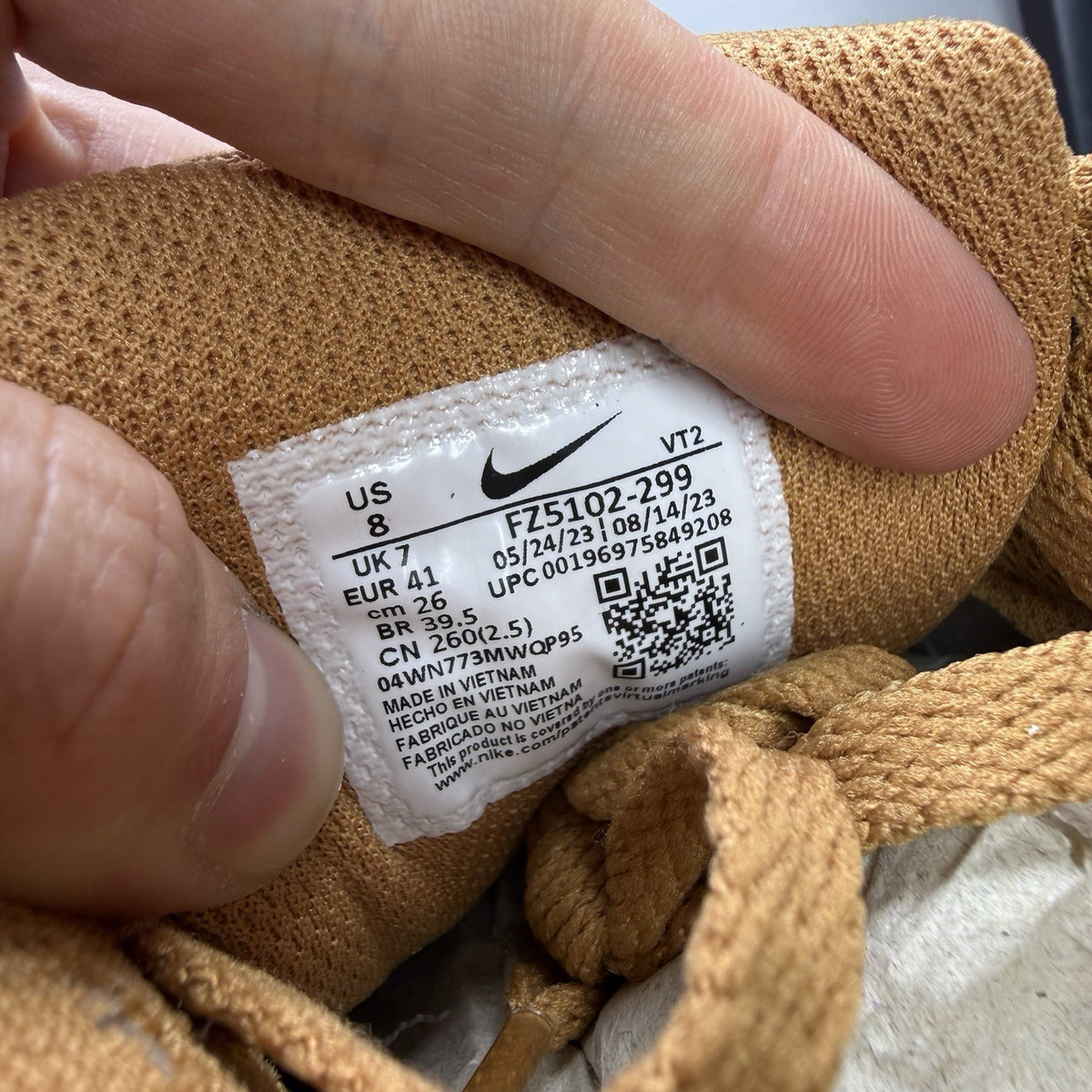 Nike Air Max 90 Premium beige trainers with gum sole and subtle branding details.