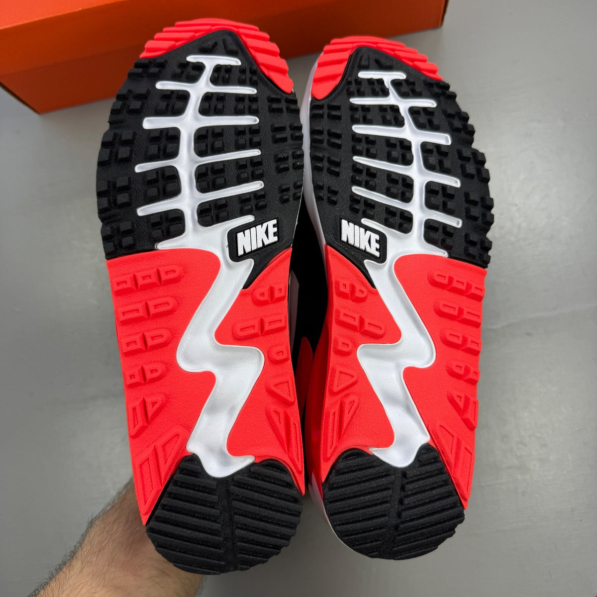 Nike trainers black with infrared accents and grey detailing, featuring Air Max cushioning.