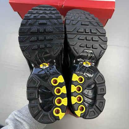 Nike Air Max Plus TN black trainers featuring distinctive wavy design and cushioned sole.