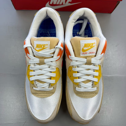 Nike Air Max 90 SE white trainers with orange accents and signature logo.