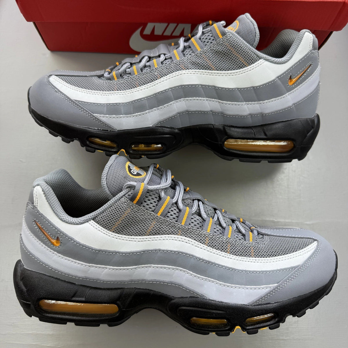 Nike Air Max 95 grey trainers with sundial accents and signature logo details.
