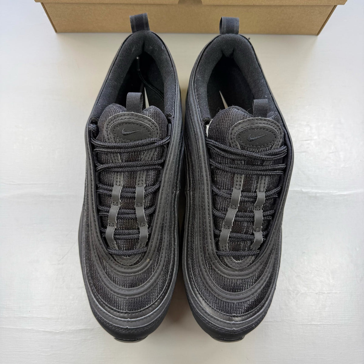 Nike Air Max 97 black low top trainers with sleek design and signature logo.