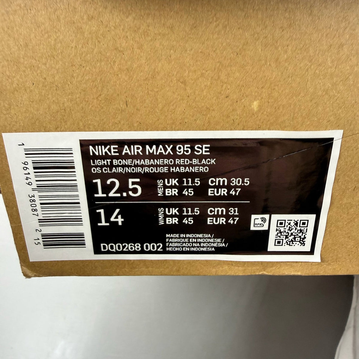 Nike Air Max 95 white trainers with red accents and textured mesh upper.