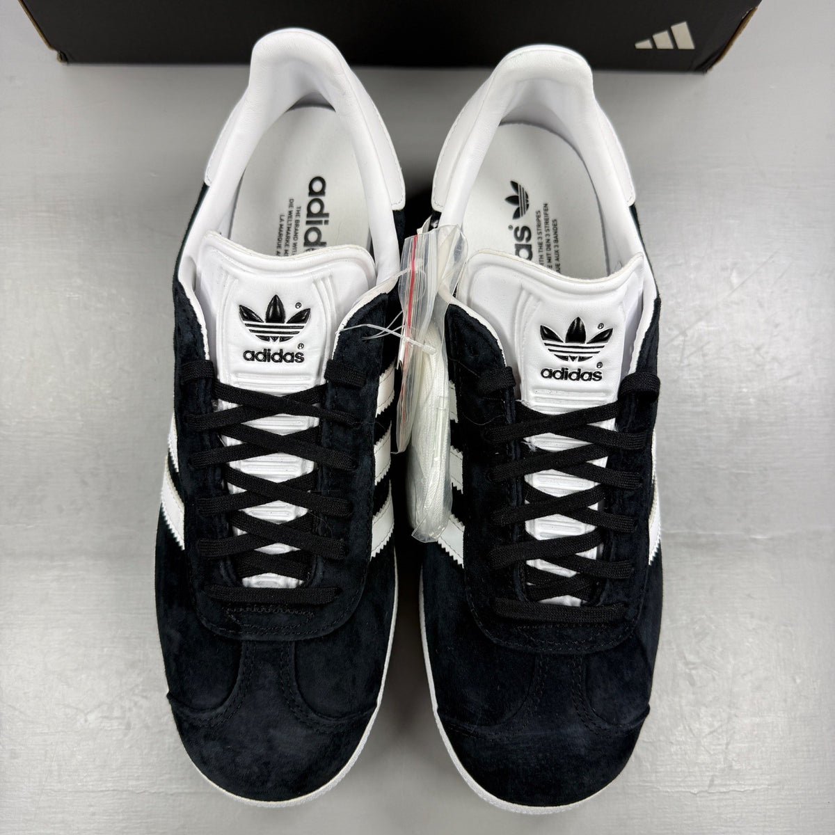 Adidas black athletic shoes with white stripes and logo, size UK 7.5.