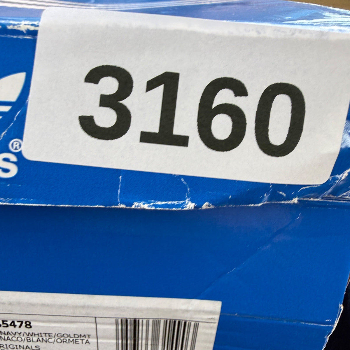 Adidas blue suede trainers with white stripes and logo detail.