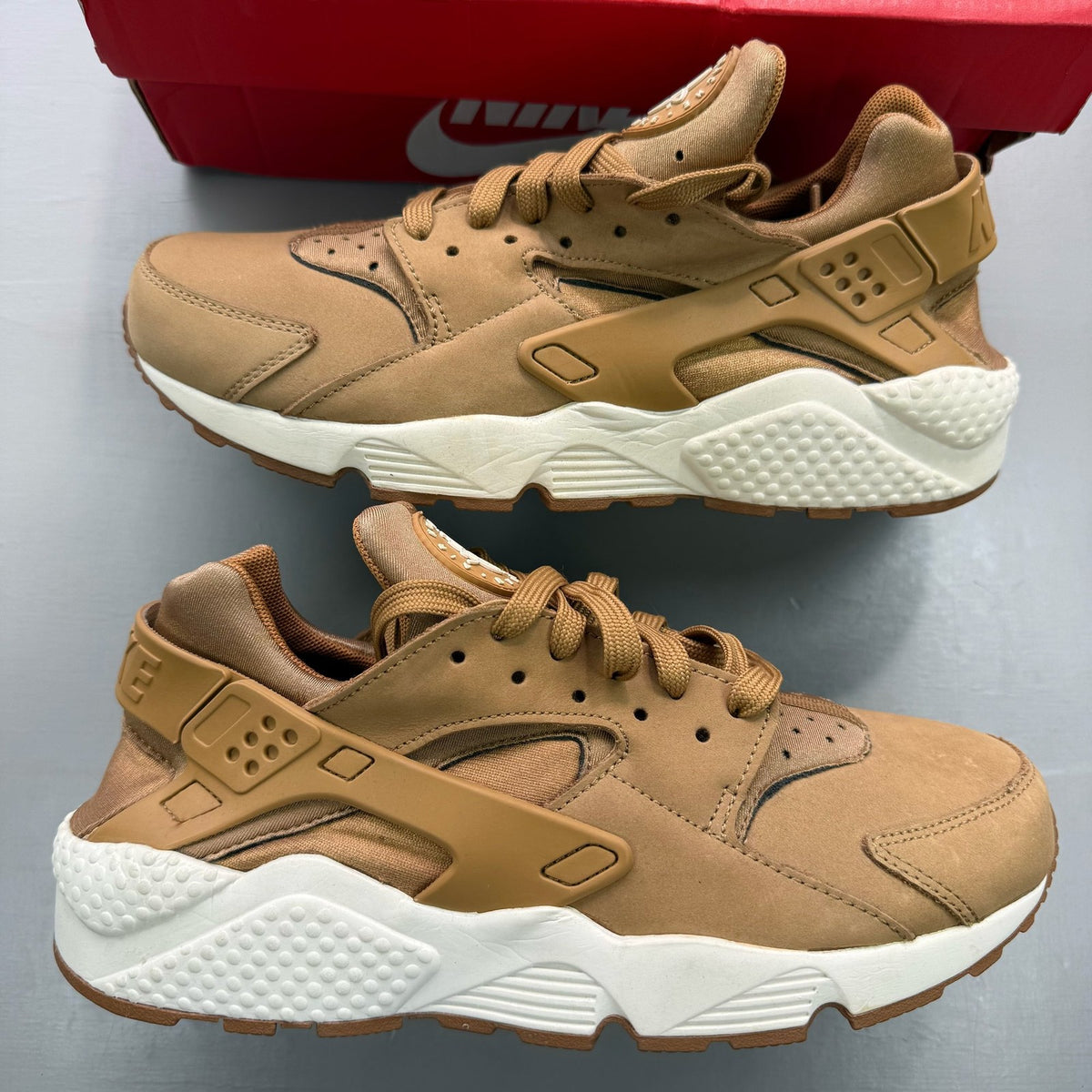 Nike brown trainers with gum sole and white accents, featuring iconic Huarache design.