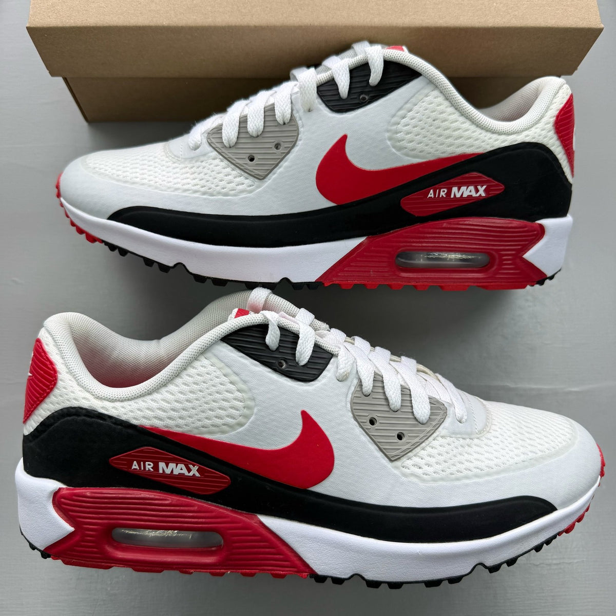 Nike Air Max 90 white trainers with red accents and logo, used condition.