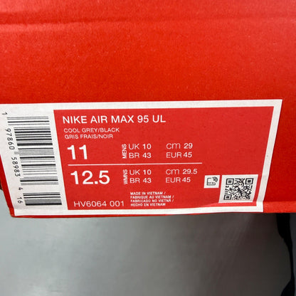 Nike Air Max 95 grey trainers with caution strip detailing and black accents.