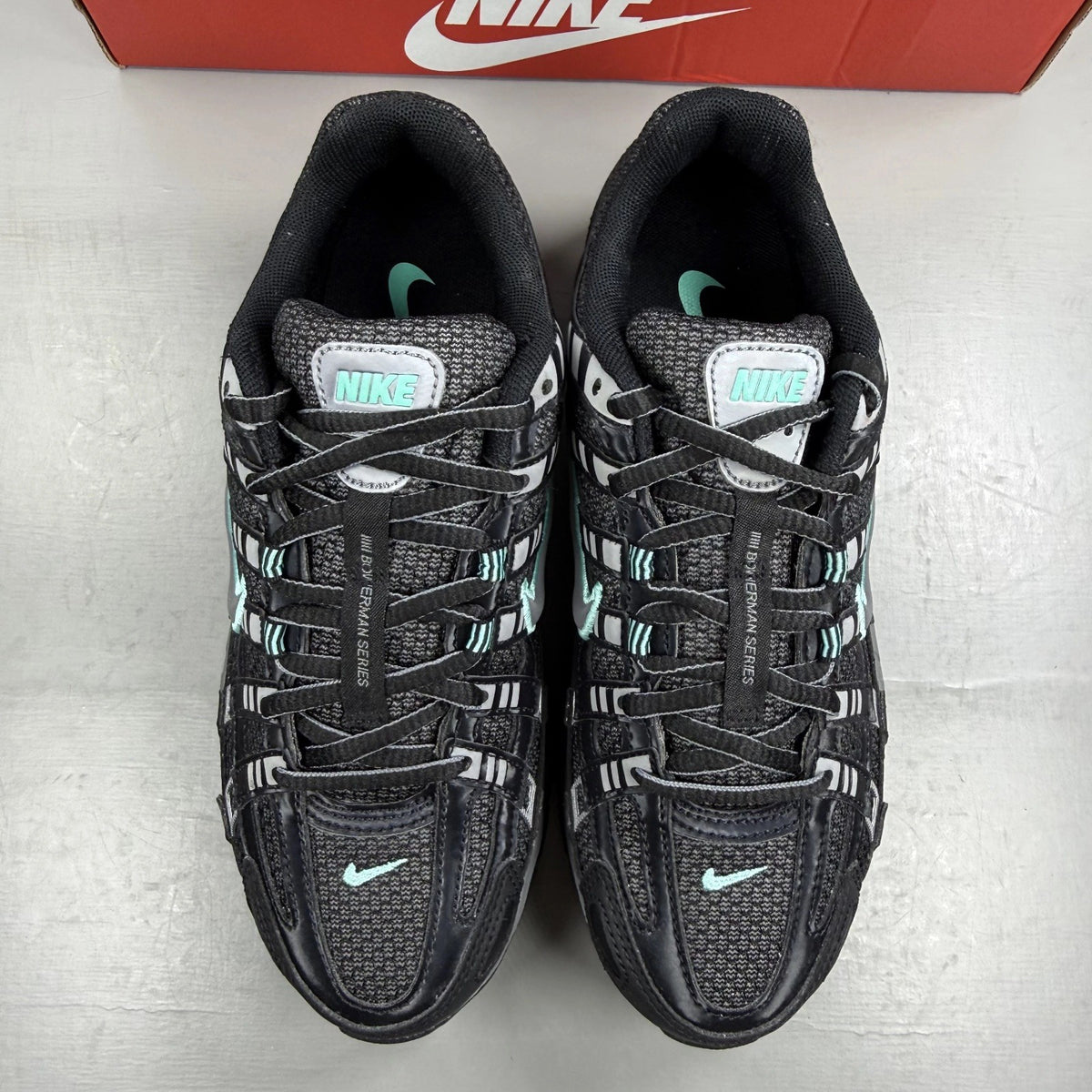 Nike black trainers with Cool Grey and Hyper Turquoise accents, featuring a sleek design.