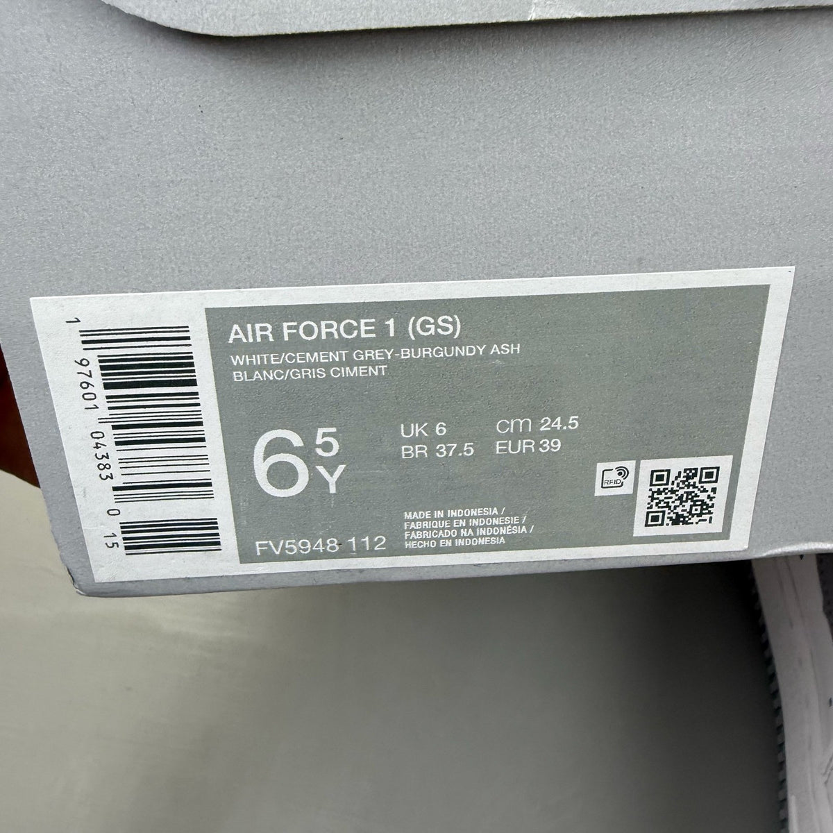 Nike Air Force 1 low white trainers with grey cement accents and logo detailing.