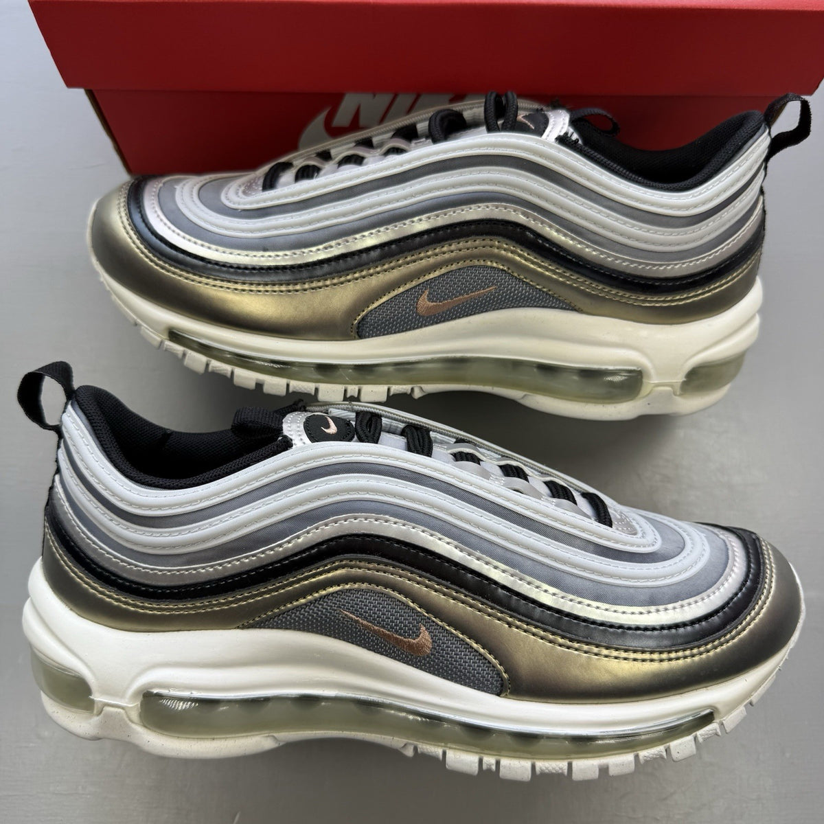 Nike Air Max 97 SE metallic silver trainers with bronze accents and white sole.